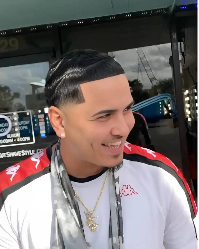 Frontal display of a blowout taper hairstyle featuring a robust, curly texture on top, harmoniously transitioning into a smart taper fade that gives a clean and stylish appearance.